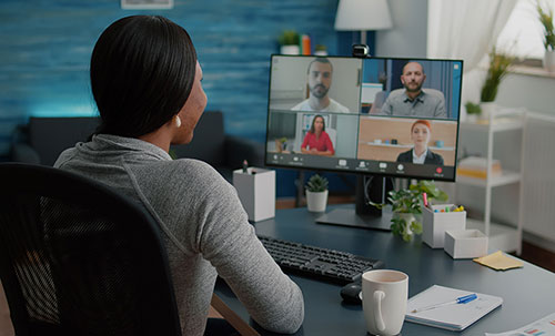 Uma mulher fazendo uma reuniao com seus colgas de trabalho online.